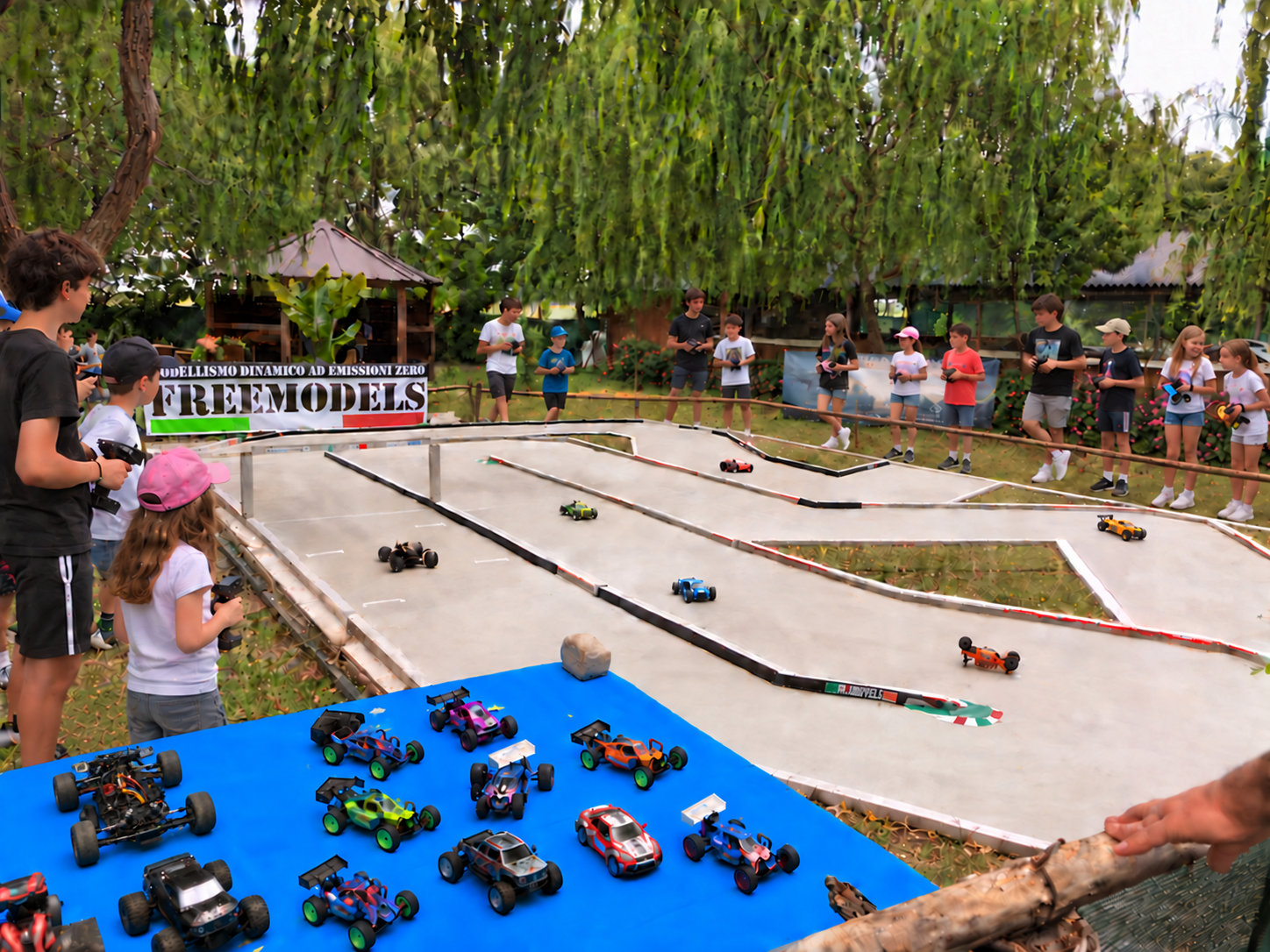 Bambini e ragazzi con radiocomandi attorno alla pista OnRoad durante un Open Day Freemodels